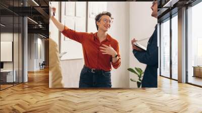 Female team leader having a discussion with her colleagues Wall mural