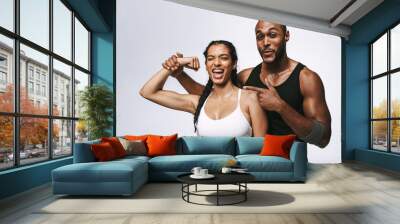 Fit couple having fun showing biceps Wall mural