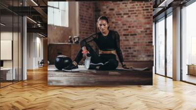 Fit woman resting after workout Wall mural