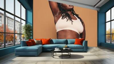 Fit woman with dreadlocks standing in a studio in sportswear Wall mural