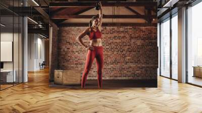 Fitness woman doing exercising with kettle bell Wall mural