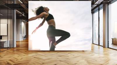 Fitness woman doing work out on rooftop Wall mural