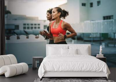 Fitness women running together on rooftop Wall mural