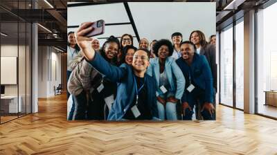 Friendly group of happy colleagues taking a group selfie photo at a corporate event Wall mural