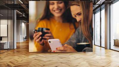 Friends using a smart phone at coffee shop Wall mural