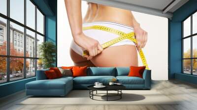 Girl in white underwear measuring her body Wall mural