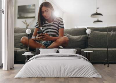 Girl listening to music sitting on couch Wall mural