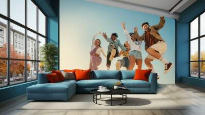 Group of happy friends jumping and having fun on a sunny day Wall mural