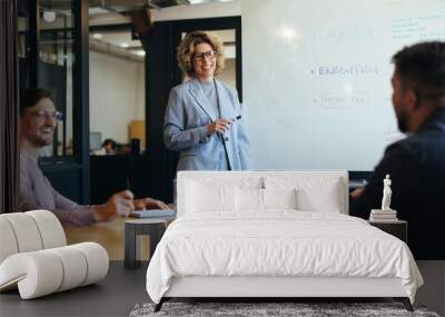 Group of professionals having a discussion in a meeting. Business woman stands in a boardroom doing a presentation Wall mural