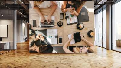 Group of women working together in coffee shop Wall mural