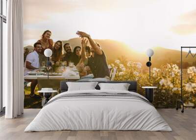 Group selfie at outdoor dinner party Wall mural