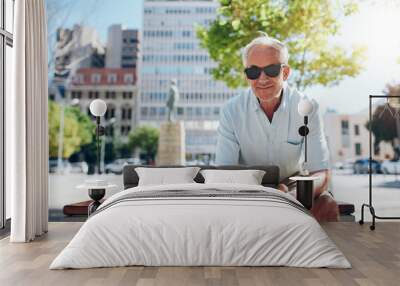 Handsome senior man sitting outdoors in the city Wall mural