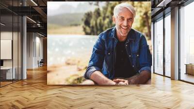 Happy and healthy senior man smiling while enjoying an active lifestyle in nature and outdoor camping Wall mural