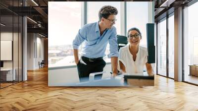 Happy business colleagues working together at their desk Wall mural