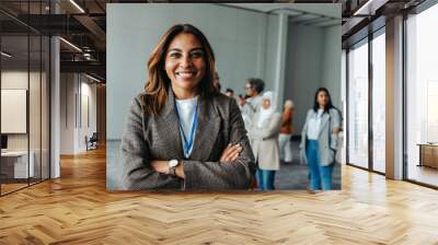 Happy businesswoman smiling at conference with diverse group of professionals in the background Wall mural