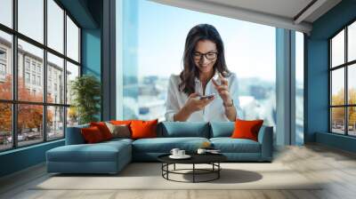 happy businesswoman using her mobile phone at office. Wall mural