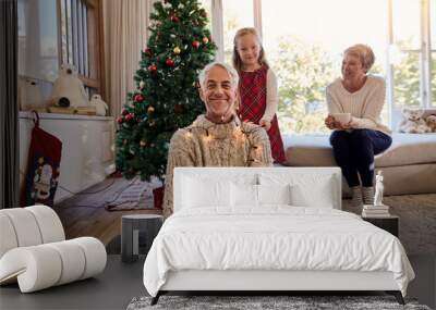 Happy family arranging the christmas lights and having fun Wall mural