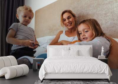 Happy family reading a bedtime storybook Wall mural