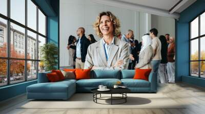 Happy female CEO at a business conference with diverse colleagues in the background Wall mural