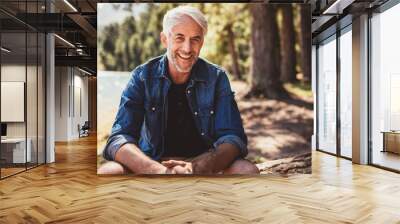 happy mature man sitting near a lake Wall mural