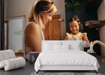 Happy mother and daughter washing dishes in the kitchen Wall mural