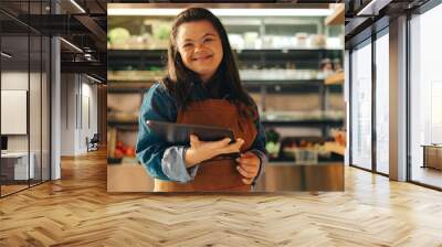 Happy store employee with Down syndrome standing in a supermarket Wall mural