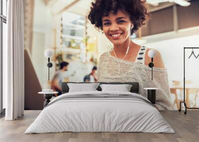 Happy young african woman  at cafe with a laptop Wall mural