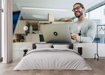 Happy young businessman working in a co-working office Wall mural