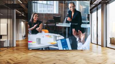 Happy young businesswoman being applauded by her team in an offi Wall mural