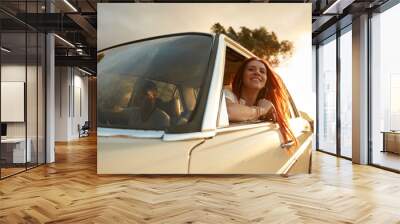 Happy young woman going on a road trip with her boyfriend Wall mural