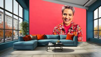 Happy young woman smiling at the camera in a studio Wall mural