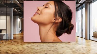 Happy young woman with healthy skin showing skincare.  Wall mural