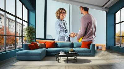 Hiring manager shaking hands with a job candidate in an office Wall mural