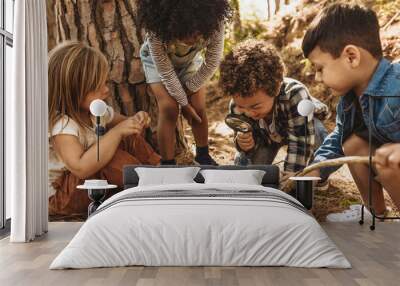 Kids exploring in forest with a magnifying glass Wall mural