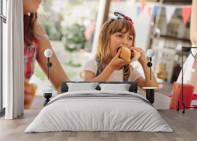 Little girl eating snacks at a restaurant Wall mural