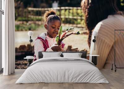 Little girl helping her mother in the garden Wall mural