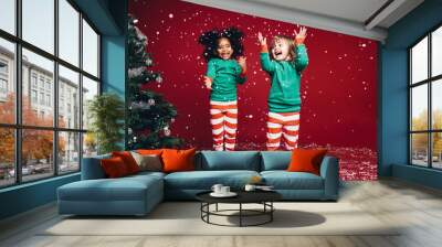 Little girls playing with artificial snow flakes Wall mural