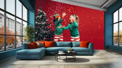 little girls playing with the artificial snow flakes Wall mural