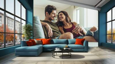 Loving couple relaxing on sofa Wall mural