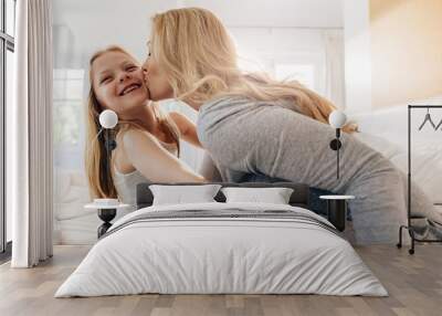 Loving mother and daughter on bed Wall mural