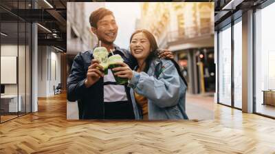 Loving young couple walking on a city street Wall mural