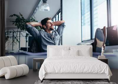 male designer sitting relaxed at his workplace Wall mural