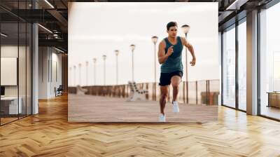 Male runner sprinting outdoors in morning Wall mural