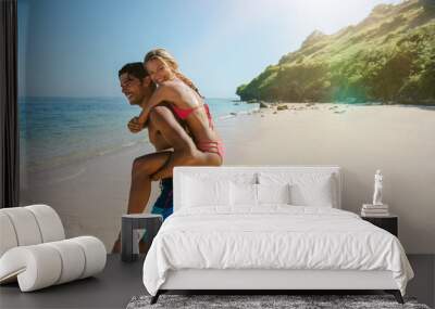 Man piggybacking woman on the beach Wall mural