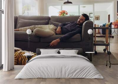 Man sleeping on couch at home Wall mural