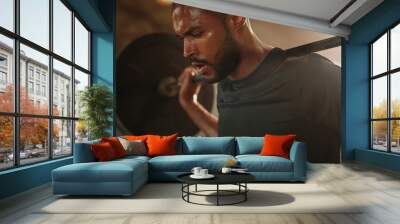 Man working out at gym with heavy weights Wall mural