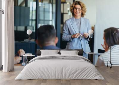 Mature business woman having a discussion with her team. Woman leading a meeting in an office Wall mural