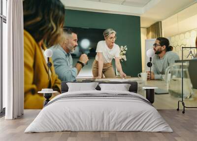 Mature businesswoman leading a meeting in a boardroom Wall mural