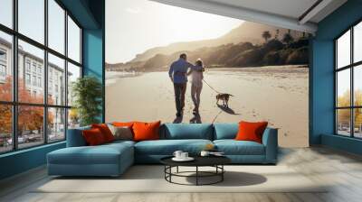 Mature couple strolling along the beach with dog Wall mural