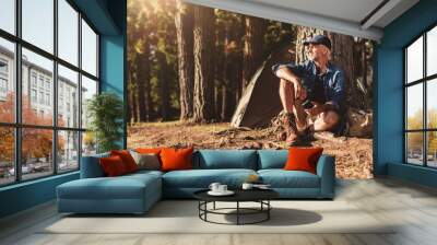 Mature man sitting at a campsite Wall mural